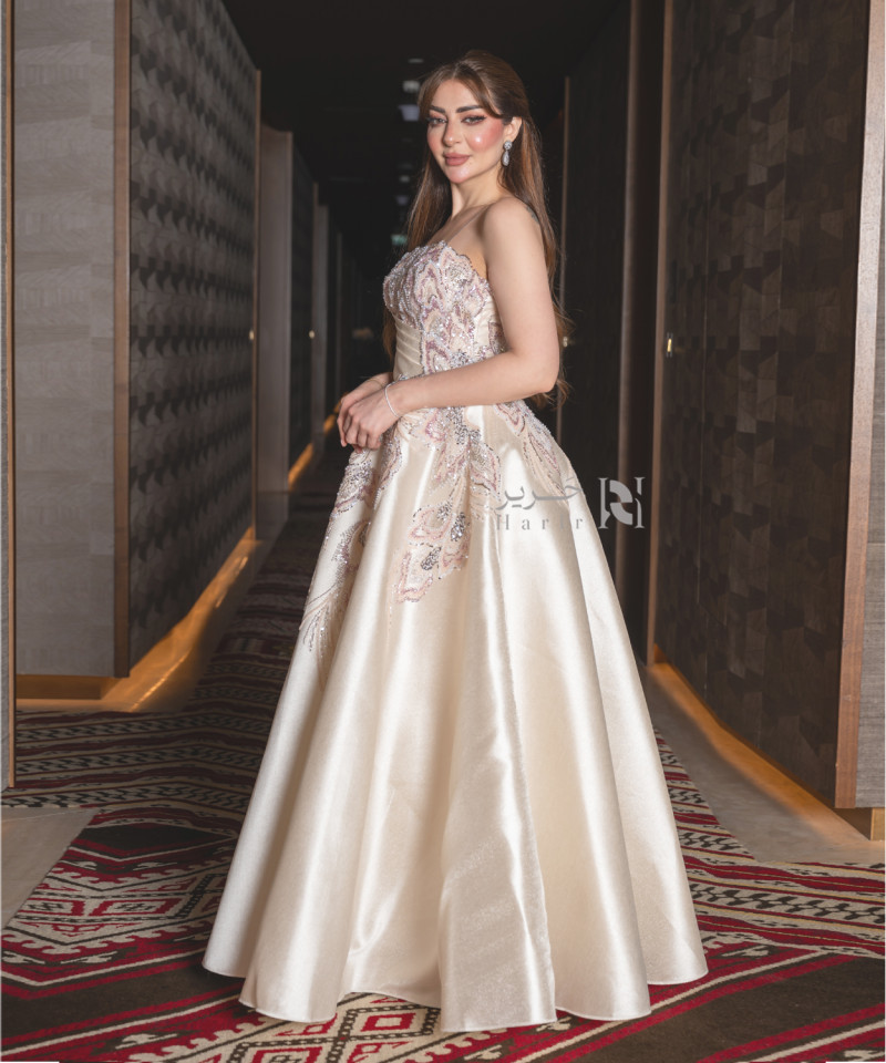 A luxurious evening gown in a pearl-toned ivory color with an elegant design