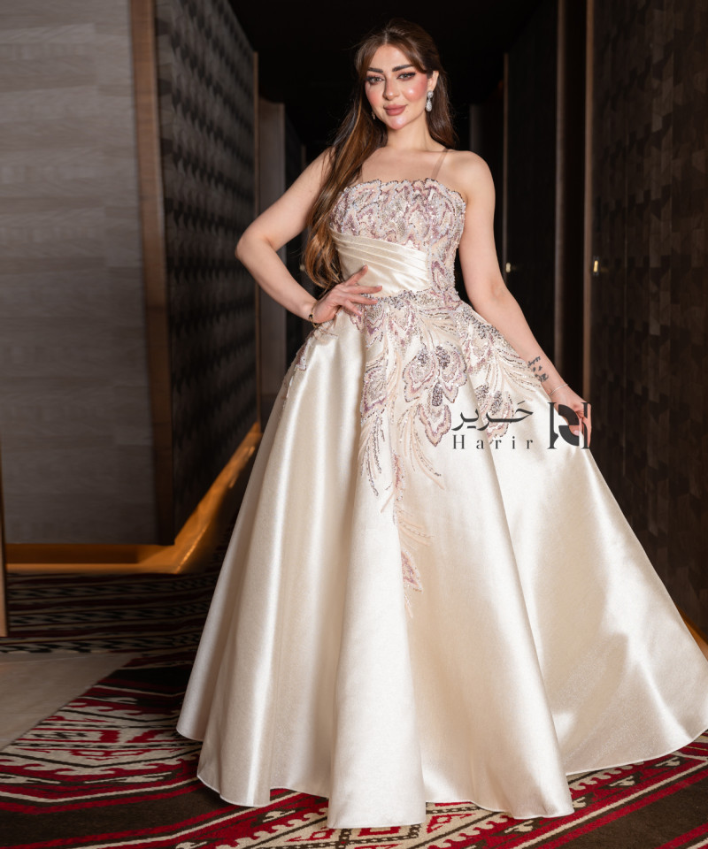 A luxurious evening gown in a pearl-toned ivory color with an elegant design