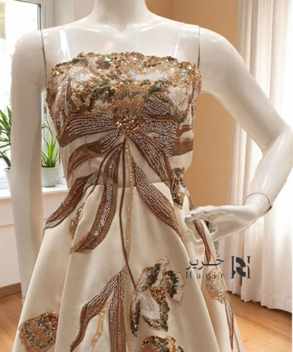 فستان سهرة عاجي بكورسيه مطرز وقصة واسعة ساحرة