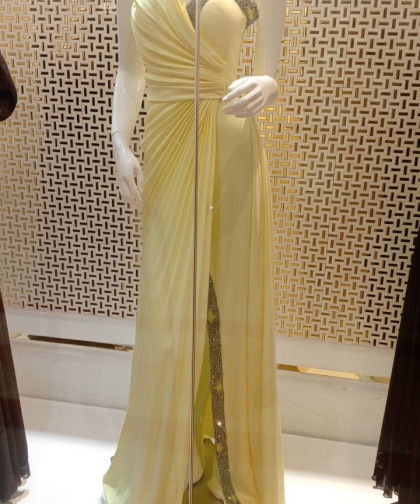 فستان أصفر بكسرات مائلة وتطريز ترتر أنيق على الصدر