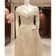 فستان بيج ملكي بأكتاف ساقطة وتطريز زهور لامعة