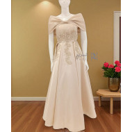 فستان بيج ساتاني مطرّز بفيونكة ملكية على الكتفين