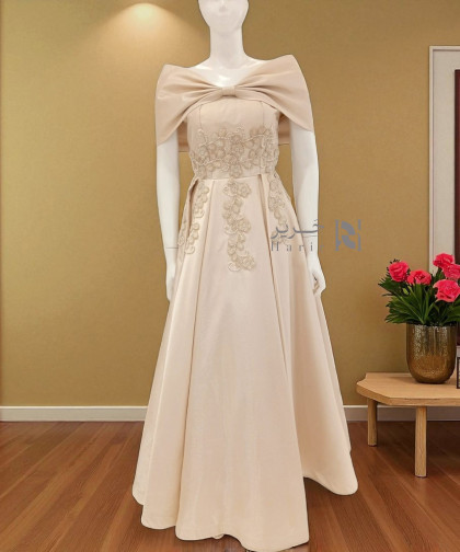 فستان بيج ساتاني مطرّز بفيونكة ملكية على الكتفين