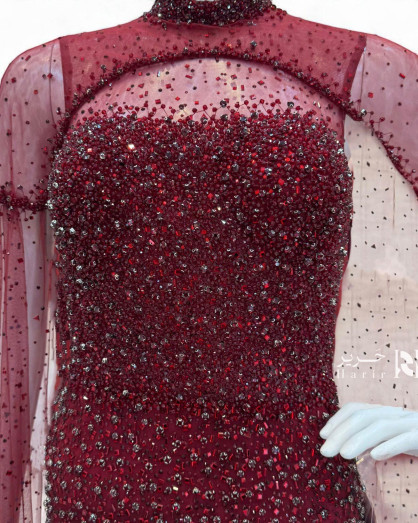 A burgundy gown embellished with shimmering sequins and a luxurious sheer cape. - A burgundy gown embellished with shimmering sequins and a luxurious sheer cape. -
