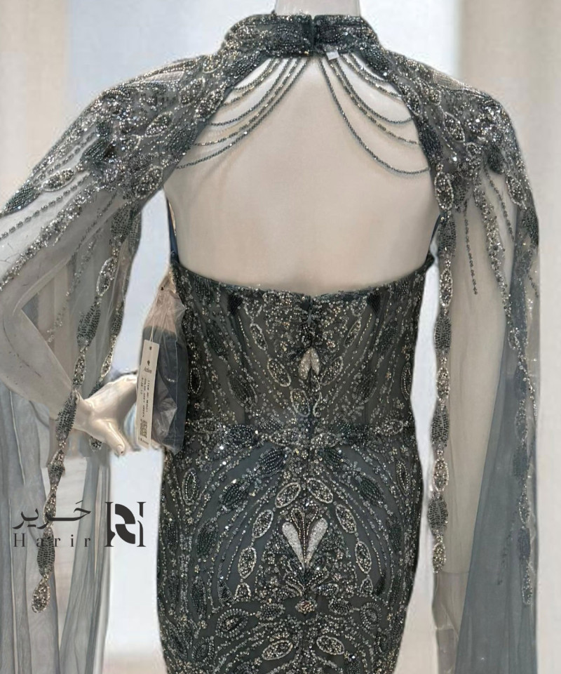 فستان سهرة رمادي مائل للأخضر بكاب فاخر وتطريز كريستالات يدوية