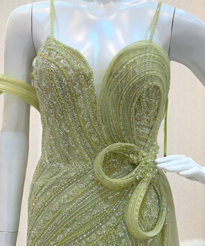 فستان سهرة أخضر فاتح مزين بالترتر مع وردة جانبية