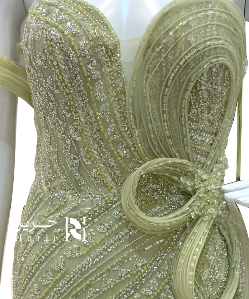 فستان سهرة أخضر فاتح مزين بالترتر مع وردة جانبية