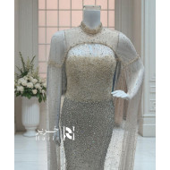Beige evening dress embroidered with a luxurious shimmering cape.  