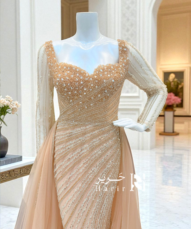 فستان سهرة مشمشي بتطريز فاخر وأكمام طويلة شفافة