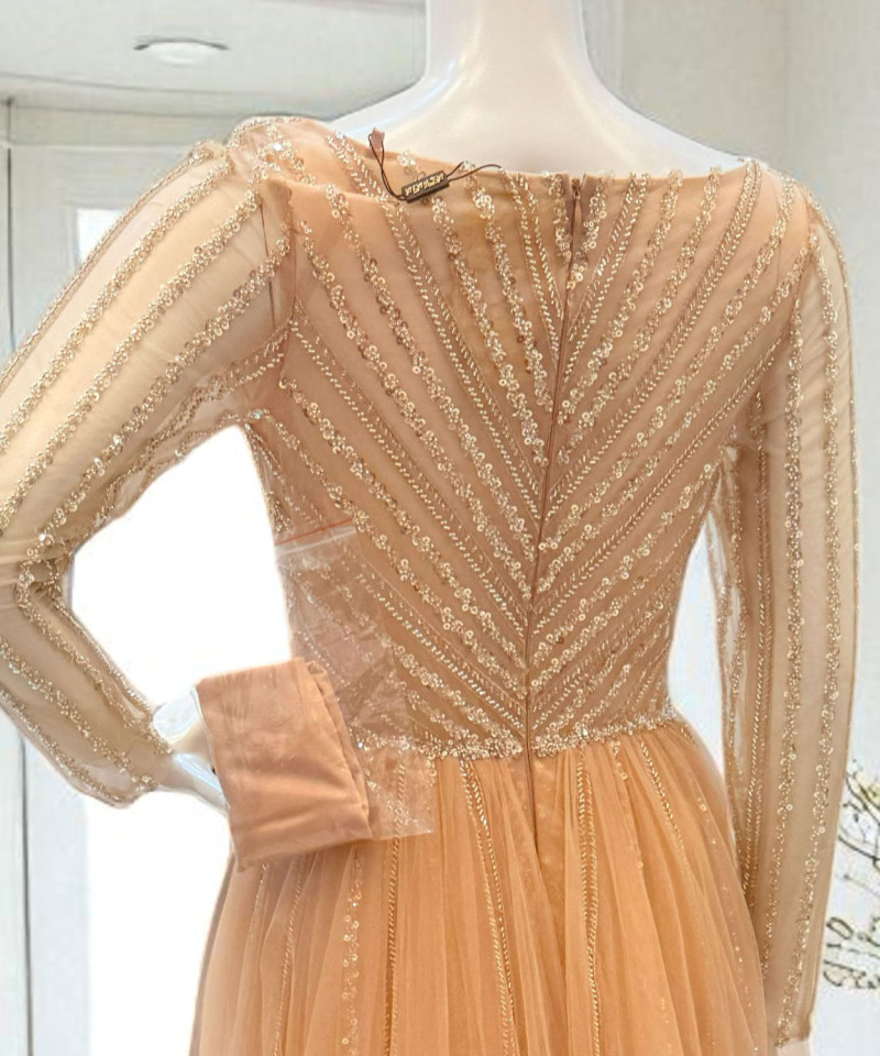 فستان سهرة مشمشي بتطريز فاخر وأكمام طويلة شفافة