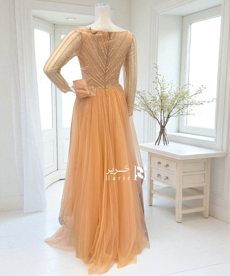 فستان سهرة مشمشي بتطريز فاخر وأكمام طويلة شفافة