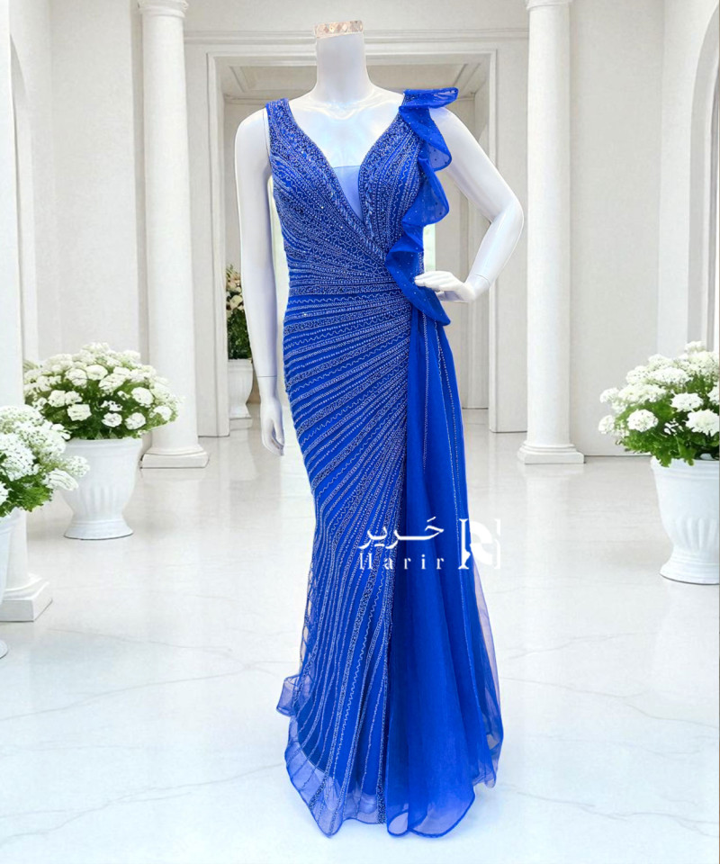 فستان سهرة أزرق ملكي مطرّز بتفاصيل لامعة وانسيابية جذابة