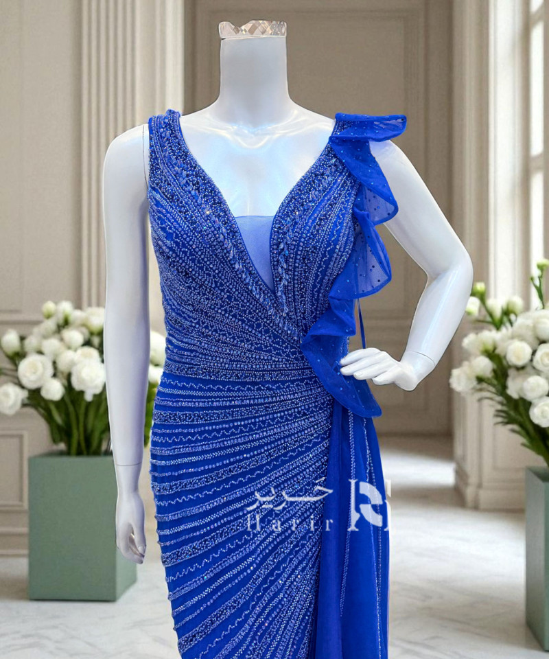 فستان سهرة أزرق ملكي مطرّز بتفاصيل لامعة وانسيابية جذابة