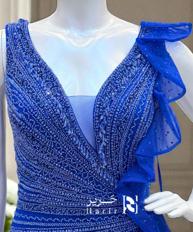 فستان سهرة أزرق ملكي مطرّز بتفاصيل لامعة وانسيابية جذابة