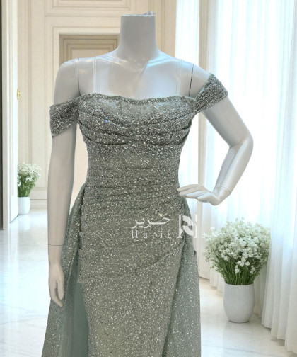 فستان سهرة أخضر مائل للرمادي مطرّز بالكامل بلمعة ناعمة وقصة أوف شولدر فاخرة