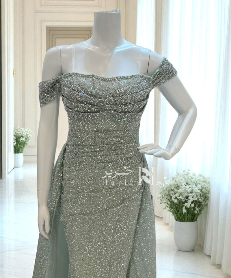 فستان سهرة أخضر مائل للرمادي مطرّز بالكامل بلمعة ناعمة وقصة أوف شولدر فاخرة