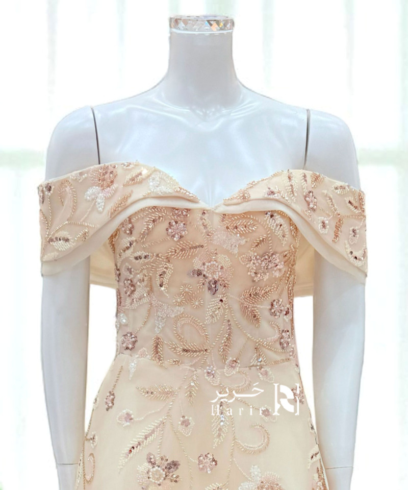 فستان سهرة بيج مطرّز بأكتاف ساقطة ورباط خلفي