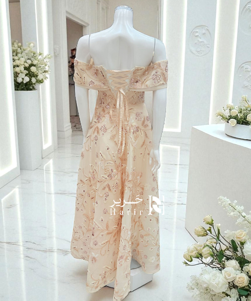 فستان سهرة بيج مطرّز بأكتاف ساقطة ورباط خلفي