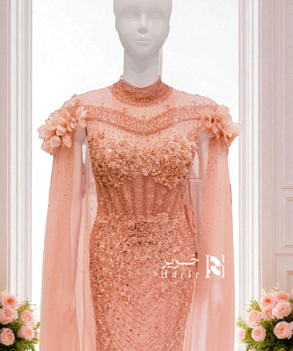 فستان سهرة مشمشي فاخر بتطريز لامع وكاب طويل مزين بالورود