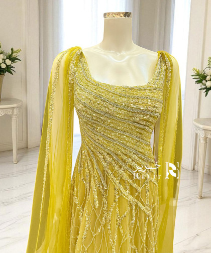 فستان سهرة أصفر فاخر بتطريز يدوي وانسيابية تول