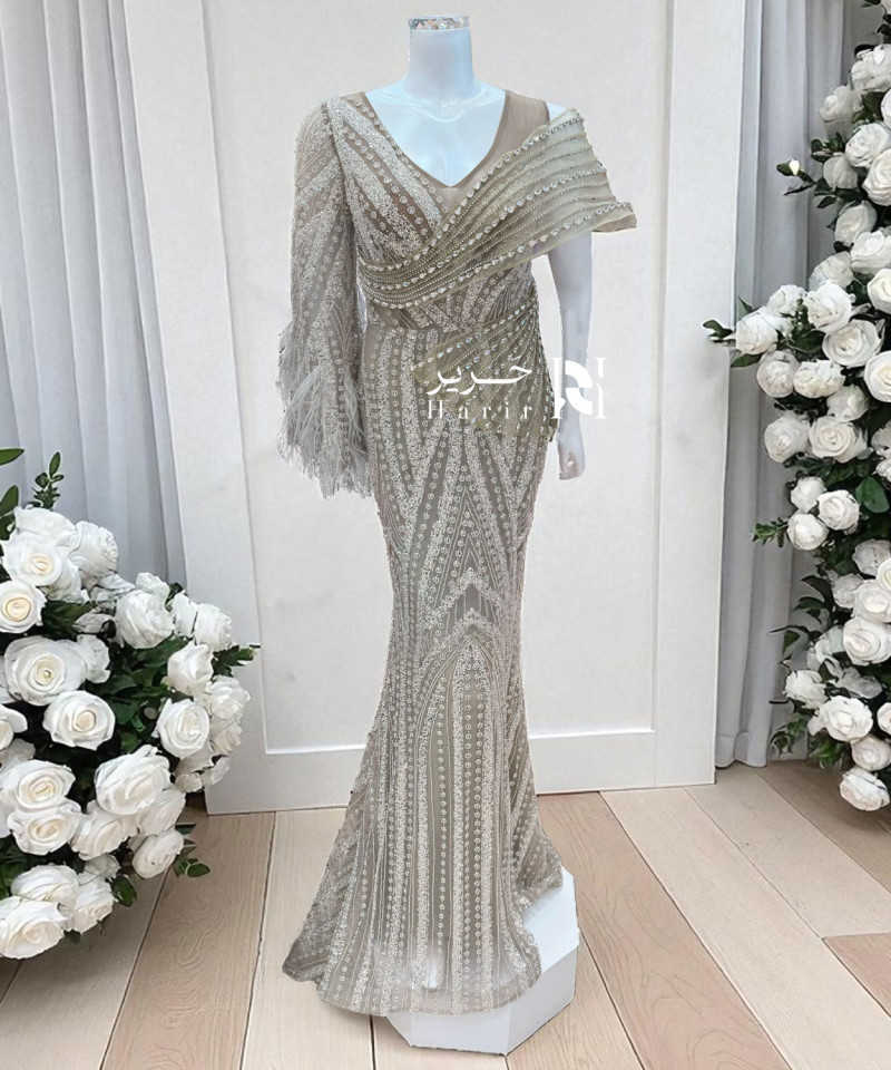فستان سهرة بني فاتح بتطريز فاخر وكتف مائل بتفاصيل كريستالية
