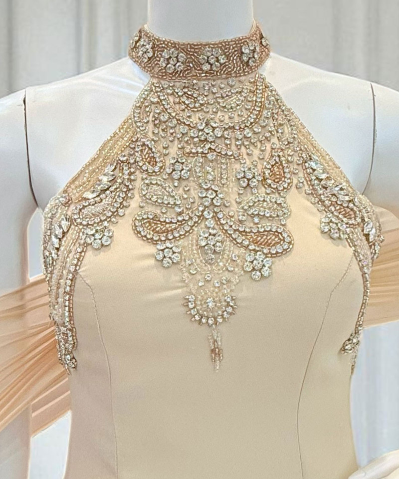 فستان سهرة عاجي مطرّز برقبة مرتفعة وربطة خلفية