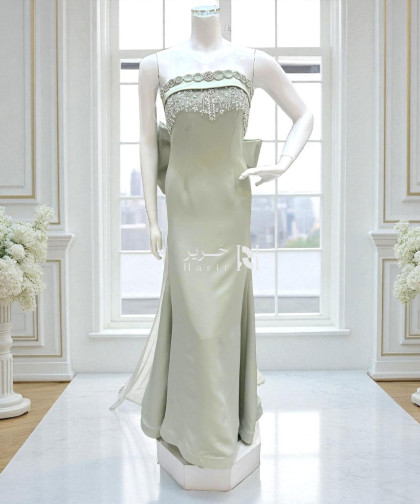 فستان سهرة أوف وايت مطرّز بكريستال مع فيونكة خلفية ملكية