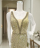 فستان سهرة ذهبي مطرّز بالترتر والريش
