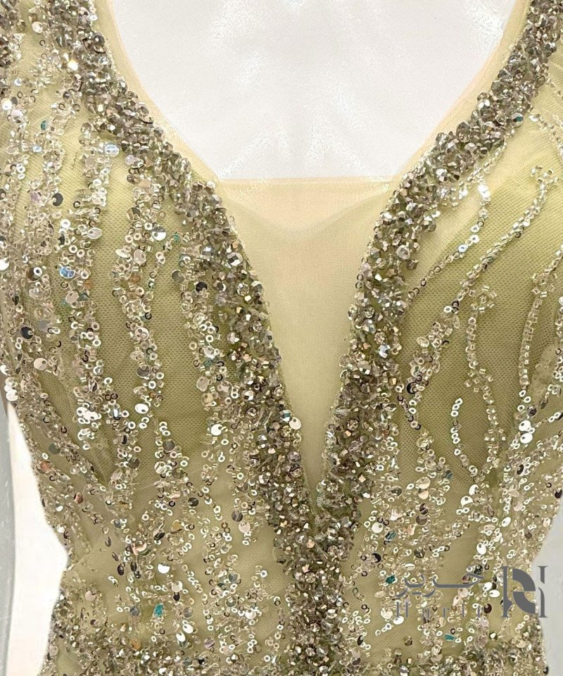 فستان سهرة ذهبي مطرّز بالترتر والريش