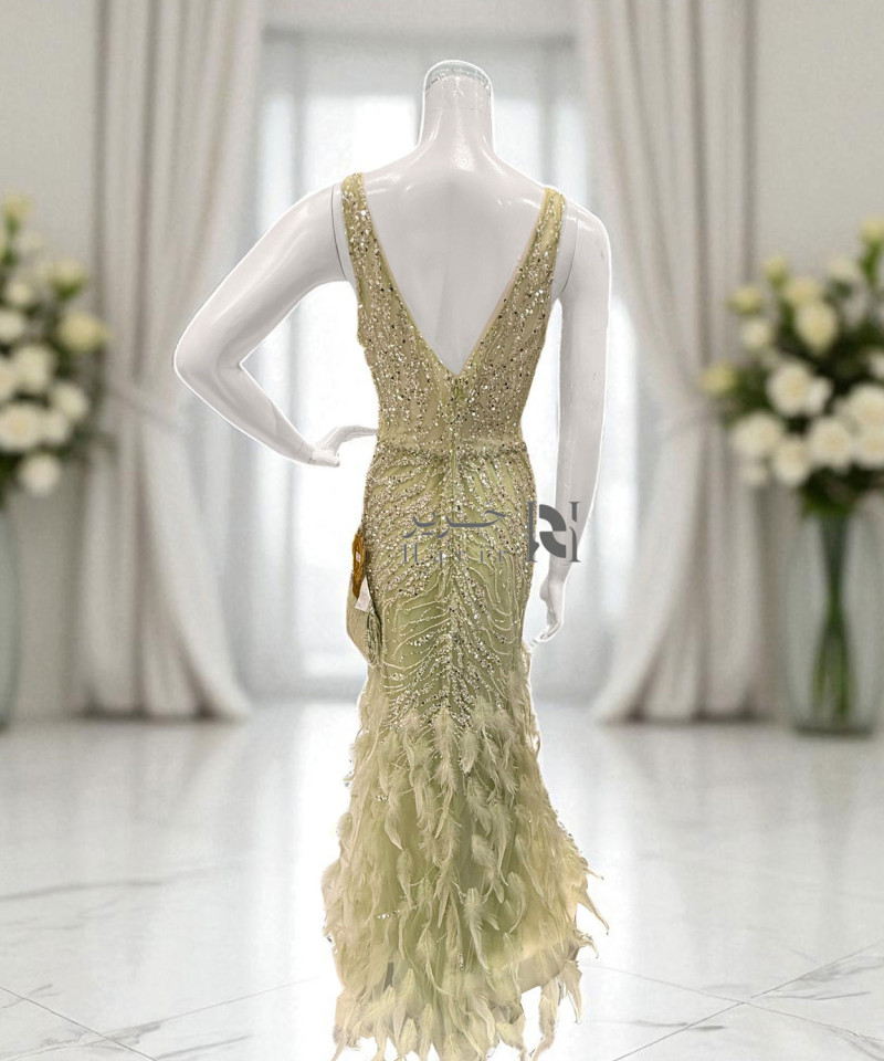 فستان سهرة ذهبي مطرّز بالترتر والريش