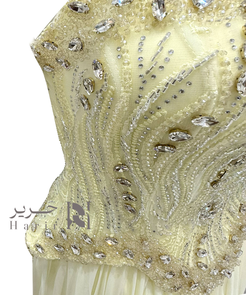 فستان سهرة عاجي مطرّز بكورساج لامع