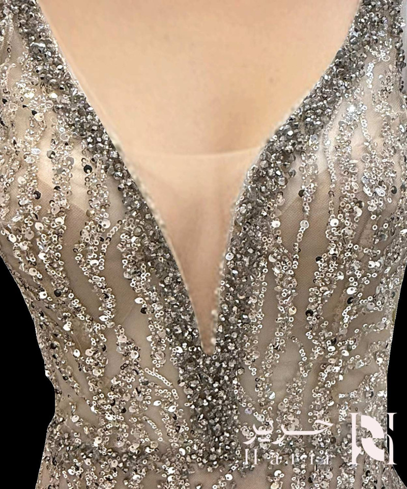 فستان سهرة شامبان فضي مطرّز بالترتر مع قصة صدر V عميقة