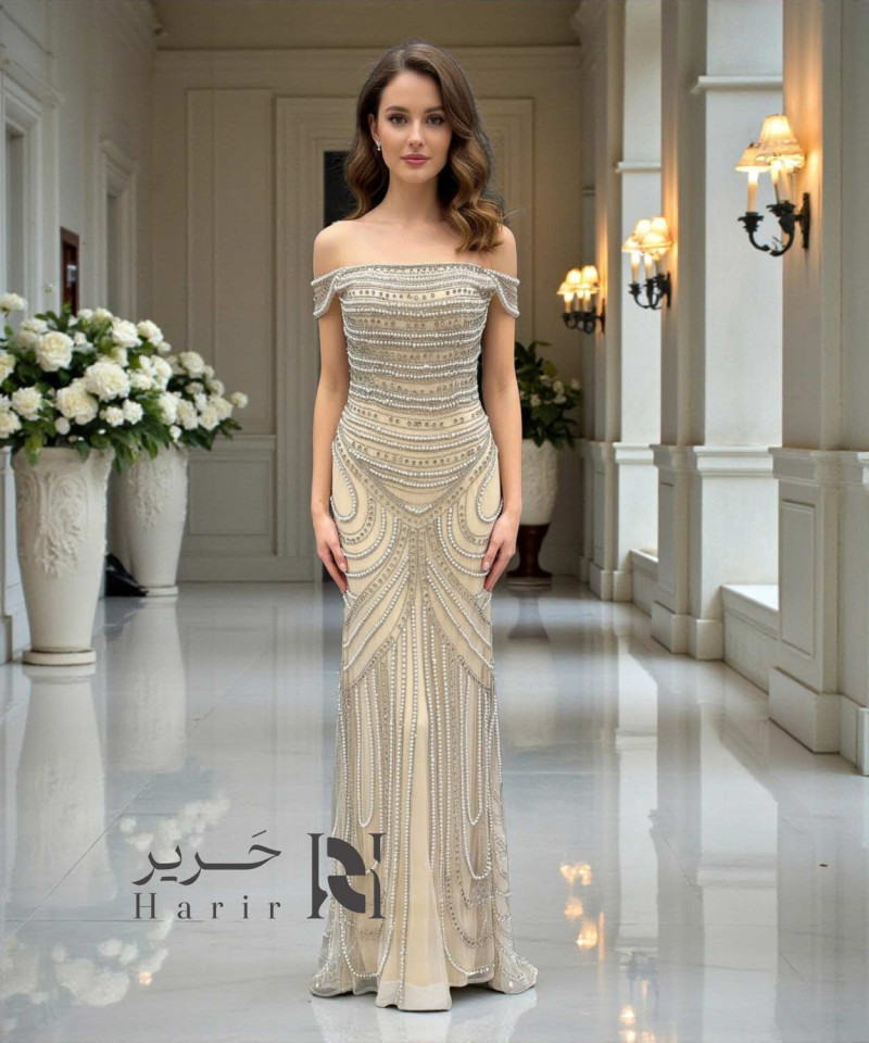 فستان سهرة شامبان مطرّز باللؤلؤ والكريستال بقصة صدر أوف شولدر أنيقة