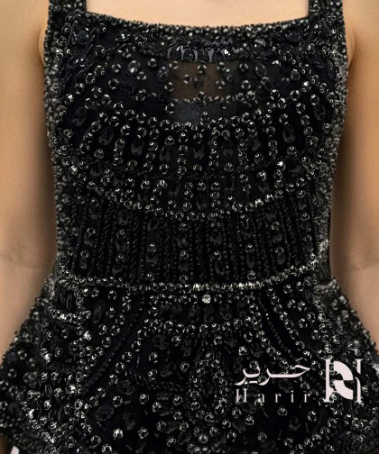 فستان سهرة أسود مطرّز بالخرز بقصة صدر مربعة وتصميم أنيق 