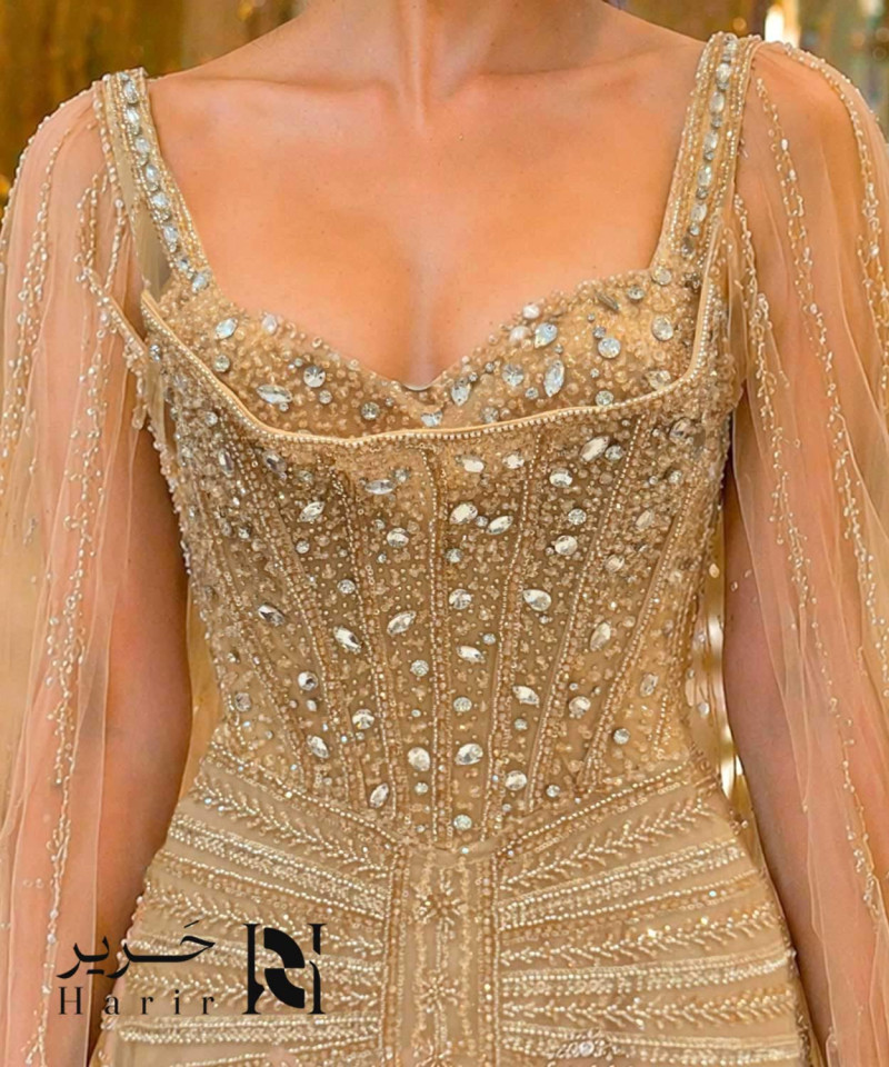 فستان سهرة ذهبي فاخر بكورسيه مرصّع وكاب تول انسيابي