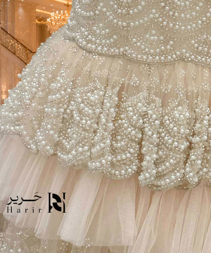 فستان سهرة وردي خوخي منفوش بتل طبقات وصدَر كورسيه مطرز باللؤلؤ