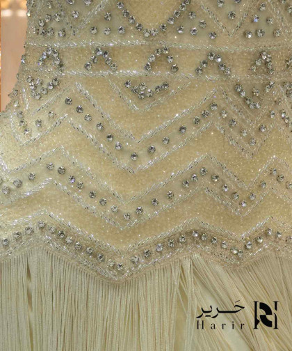 فستان سهرة أصفر فاتح بتطريز كريستال وقصة هالتر مع شراشيب