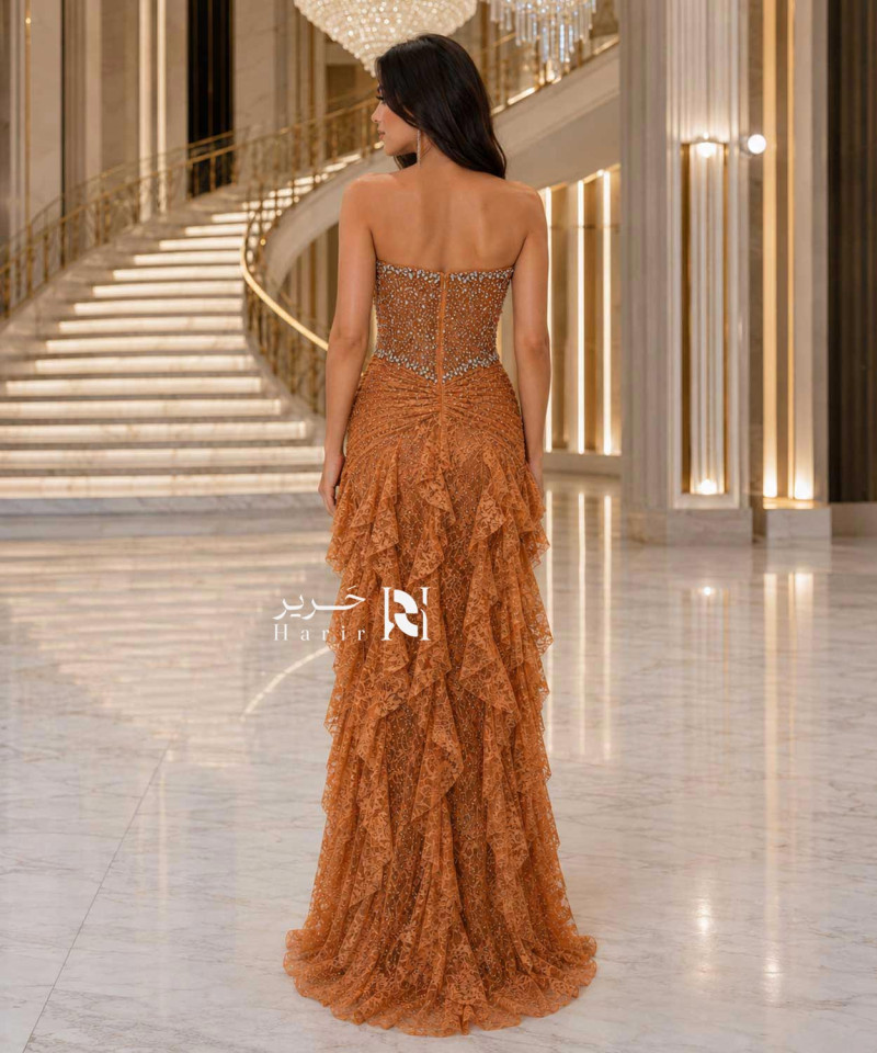 فستان سهرة برتقالي نحاسي مطرز بالكريستال بقصة كورسيه وتنورة كشكش طبقات