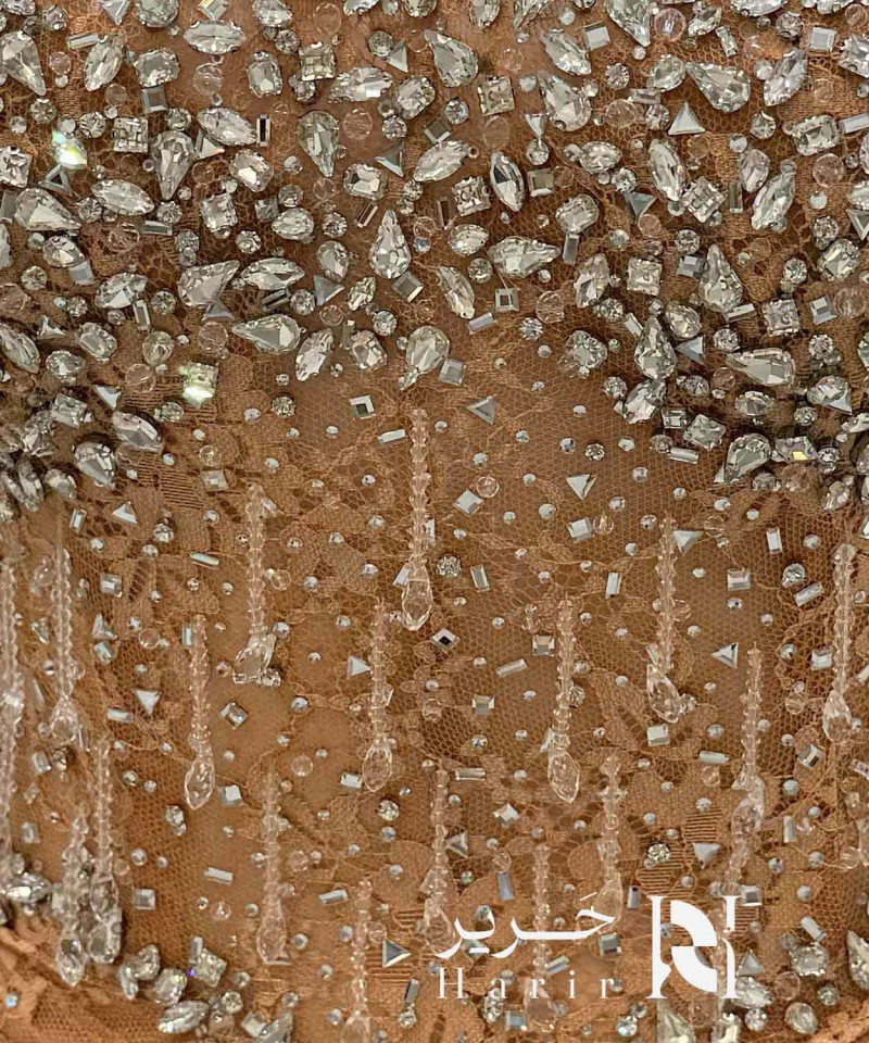 فستان سهرة برتقالي نحاسي مطرز بالكريستال بقصة كورسيه وتنورة كشكش طبقات